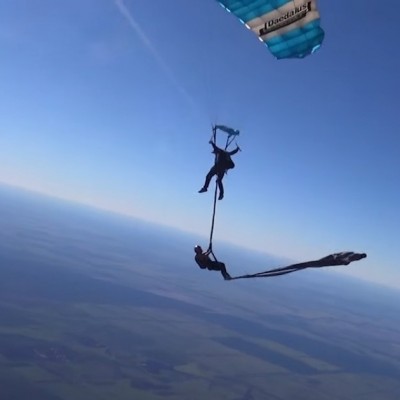  (Video) Pareja de trapecistas realiza presentación mientras saltan en paracaídas