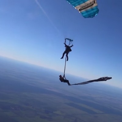  (Video) Pareja de trapecistas realiza presentación mientras saltan en paracaídas
