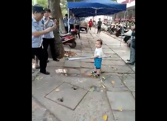  (Video) Conmueve niño chino que usa un tubo para proteger a su abuela de agentes