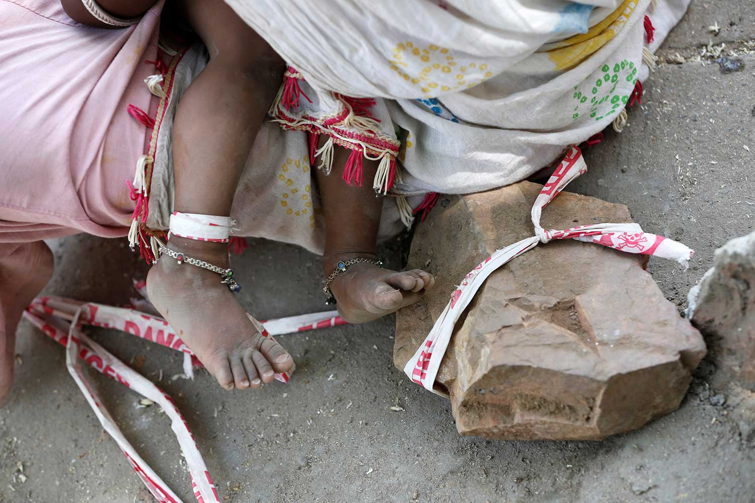  En la India, padres atan a su bebé a una piedra mientras salen a trabajar