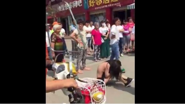  (Video) Mujer desnuda y golpea a joven en China por meterse con su marido