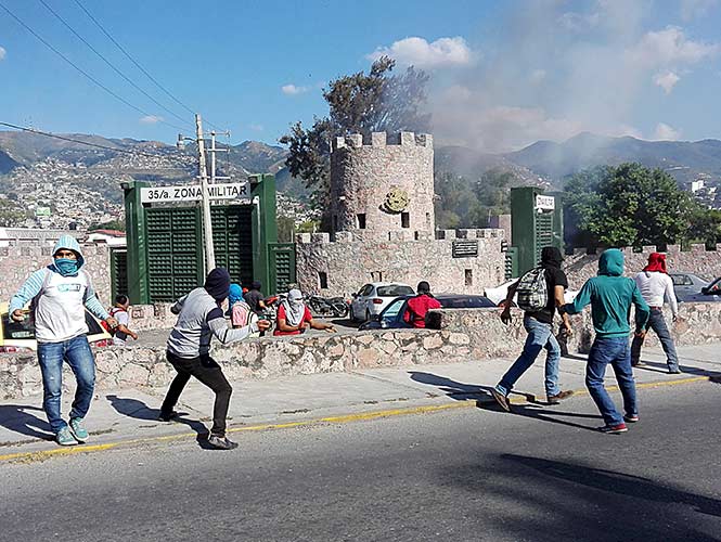  Normalistas de Ayotzinapa atacan cuartel militar con piedras y bombas molotov